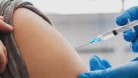 doctor in medical gloves holding syringe and giving vaccine to patient
